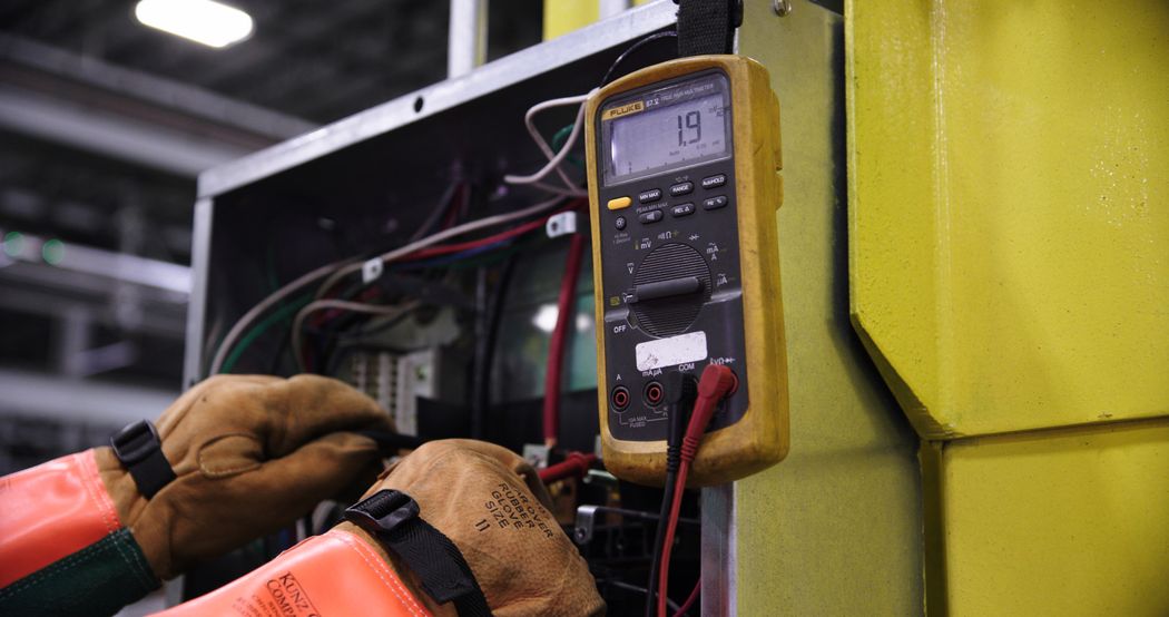 Technician checking an industrial electrical cabinet operating environment
